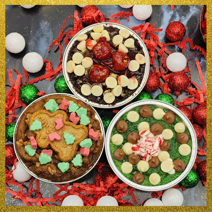 Three festive cookie tins with various toppings stuffed and goey skillet cookies
